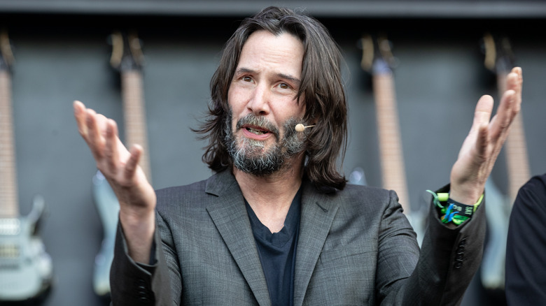 Keanu Reeves holding up hands