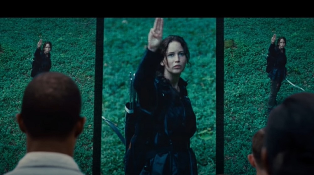Katniss Everdeen doing the three-finger salute in The Hunger Games