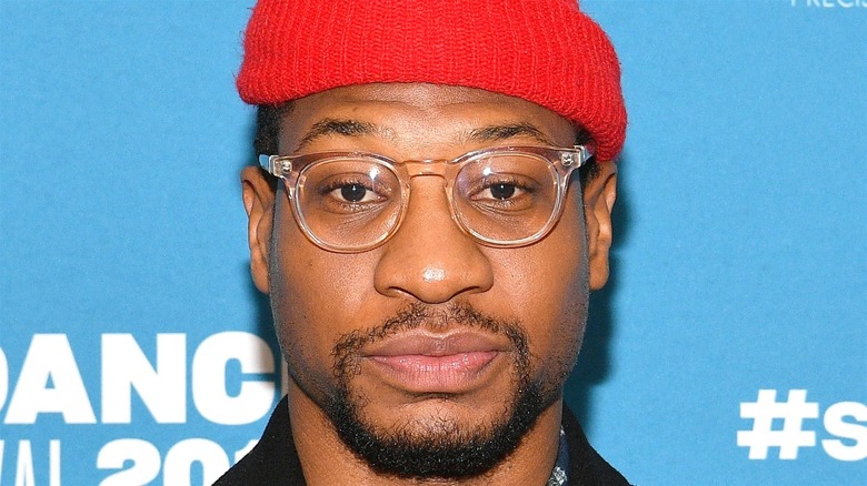 Jonathan Majors in a red cap