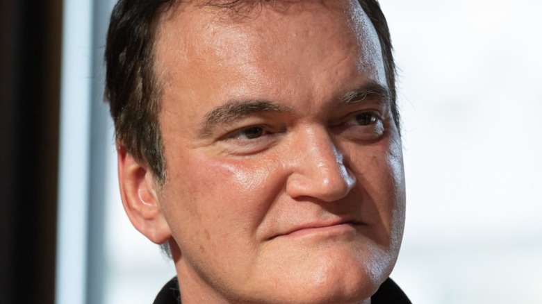 Quentin Tarantino smirking while sitting